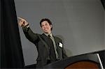 Mid adult man pointing during presentation at conference