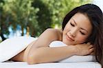 Young woman lying on massage table, outdoors