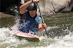Jeune homme kayak d'eau vive
