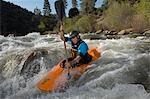 Homme en kayak sur la rivière de montagne
