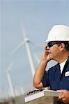 Engineer using mobile phone at wind farm