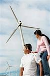 Father and daughter (7-9) near wind turbines at wind farm