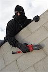 Masked thief climbing wall