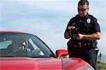 Traffic cop standing by sports car