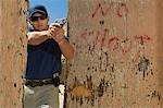 Man aiming hand gun at firing range