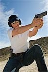 Woman aiming hand gun at firing range