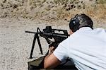 Man aiming machine gun at firing range