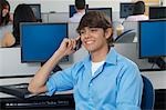 Male student using mobile phone in computer classroom