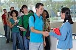 Students shaking hands with teacher on balcony in school