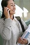 Woman using mobile phone outside school