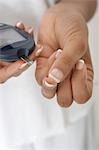 Woman taking diabetes test, close-up of hands