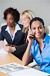 Businesswoman Using Cell Phone During meeting