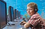 School boy portant vos écouteurs dans la salle des ordinateurs, portrait