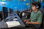 School boy wearing headphones in computer room