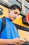 High School Boy mit MP3-Player von Schulbus