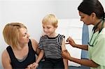 Mother supporting son receiving injection