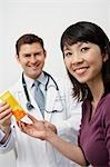 Doctor giving female patient medication in hospital