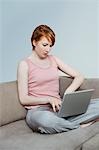 Woman using laptop on sofa