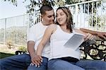 Expectant couple relaxing on bench