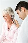 Mid adult doctor examining senior patient