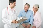 Mid adult doctor explains test results to senior couple