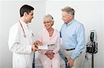 Mid adult doctor explains test results to senior couple