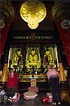 Pèlerins s'agenouillent dans le deuxième temple dans le monastère de Chuk Lam Sim (forêt de bambous) à Tsuen Wan, New Territories. Le temple est un des plus importants à Hong Kong et contient trois des plus grands bouddhas dorés sur le territoire.