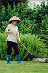 China,Hainan Province,Hainan Island,Sanya City. Nantian Hot Spring Resort - a Gardener tending the lawns.