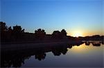 Chine, Beijing. Le reflet d'une tour de guet sur le mur du Musée du Palais Forbidden City silhouette au coucher du soleil.