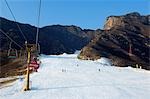 China, Peking, Shijinglong Ski Resort. Ein Skilift, wobei Skifahrer bis zu den Pisten.