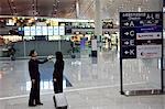 China,Beijing,Beijing Capital Airport. A Chinese business woman and welcomer at the new Terminal 3 building opened February 2008,second largest building in the world .