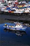 Fishing boat in front of brightly painted palafitos