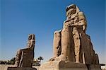 Les colosses de Memnon debout à l'entrée de l'ancienne nécropole thébaine sur la rive ouest du Nil de Louxor.