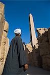 A temple guardian admires the Obelisk of Tuthmosis at Karnak Temple,Luxor.