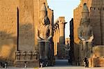 Giant statues of Ramses II stand either side of the entrance through the first pylon at Luxor Temple,Egypt