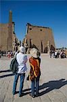 A couple admire the enormous first Pylon of Luxor Temple,Egypt