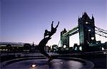 The Dolphin with a Boy statue on the banks of the Thames River beside Tower Bridge in London