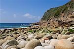 Glatte Felsbrocken säumen die Küste in Porth Nanven auf der nördlichen Küste von Cornwall Penwith Halbinsel, England