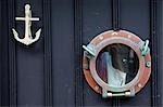 La porte de la maison de pêcheur à Mousehole a un point d'ancrage pour un heurtoir de porte et le hublot d'un navire pour un Judas, Cornouailles, Angleterre