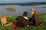 UK,Northern Ireland,Fermanagh. A couple of guests at Lough Erne Golf Resort picnic overlooking the lake .