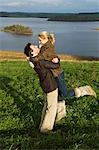 UK,Northern Ireland,Fermanagh. A couple embrace on a walk overlooking the lake at Lough Erne Golf Resort .