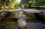 England,Somerset,Exmoor. Tarr Steps a prehistoric clapper bridge across the River Barle in the Exmoor National Park. A typical clapper bridge construction,the bridge dates to around 1000 BC. The stone slabs weigh up to 5 tons apiece. According to local legend,they were placed by the devil to win a bet.