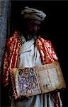 A priest holds one of the monastery's ancient illuminated texts.