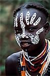 A young Karo girl has decorated herself with face paint,an intricate braided hairstyle and layers of beads. A small Omotic tribe related to the Hamar,who live along the banks of the Omo River in southwestern Ethiopia,the Karo are renowned for their elaborate body painting using white chalk,crushed rock and other natural pigments.