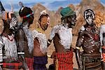 At a dance in the Karo village of Duss men stand waiting to dance. A small Omotic tribe related to the Hamar,the Karo live along the banks of the Omo River in southwestern Ethiopia. They are renowned for their elaborate body art using white chalk,crushed rock and other natural pigments.