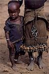 A young Dassanech girl holds her little brother. She wears a leather skirt with an elaborate fringe of wooden and metal tassles. Much the largest of the tribes in the Omo Valley numbering around 50,000,the Dassanech (also known as the Galeb,Changila or Merille) are Nilotic pastoralists and agriculturalists.