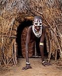 A young Karo girl in the doorway of her hut in the village of Duss. A small Omotic tribe related to the Hamar,who live along the banks of the Omo River in southwestern Ethiopia,the Karo are renowned for their elaborate body painting using white chalk,crushed rock and other natural pigments.