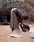 A Dassanech woman winnows grain by pouring it from her metal tin and letting it fall onto a calfskin. Much the largest of the tribes in the Omo Valley numbering around 50,000,the Dassanech (also known as the Galeb,Changila or Merille) and Nilotic pastoralists and agriculturalists.