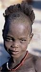 A coy young Dassanech boy with a hairstyle typical of the young boys of his tribe.The Dassanech speak a language of Eastern Cushitic origin. They practice animal husbandry and fishing as well as agriculture.