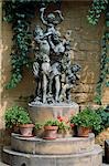 A statue of girls and children holding grapes to celebrate the wine harvest stands beside the entrance to Muga Winery on a stone plinth surrounded by flower pots